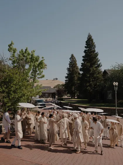 The Baraat procession for Nita and Navi's Sikh wedding in California. The coordinated umbrellas and outfits create a visually stunning and unified look.