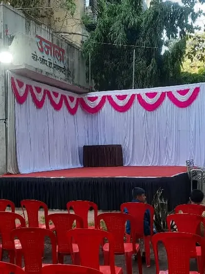 A simple stage and seating setup for a small community event. The butterfly wing props add a fun touch for a children's program.