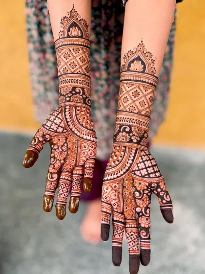 A full-arm bridal design with a prominent lotus motif at the top, combined with floral and geometric bands.