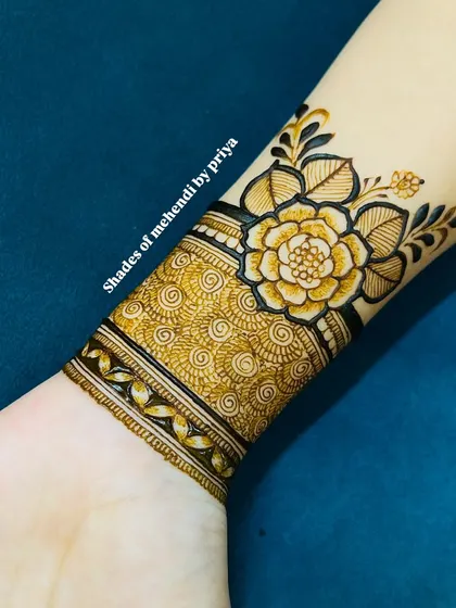 A detailed floral cuff or wristband design. This is a great option if you want something beautiful but not a full-hand mehendi.