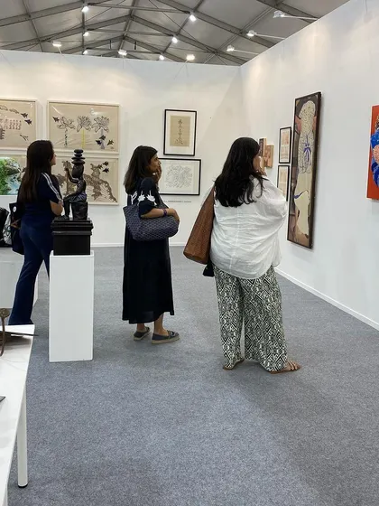 More visitors exploring the diverse collection of art at our booth.