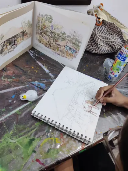 The initial sketching phase of the village scene, where the student lays out the composition before adding color.