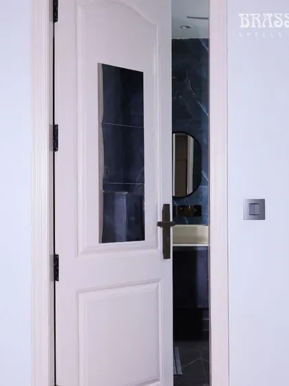 The Natali handle on a bathroom door, demonstrating its suitability for every room in the house. The consistent use of this hardware creates a polished and intentionally designed interior.