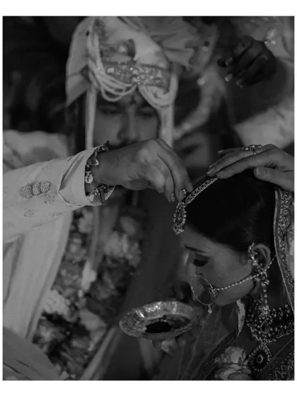 A black and white shot of the groom applying sindoor to the bride's forehead, a significant and emotional moment in a Hindu wedding ceremony.