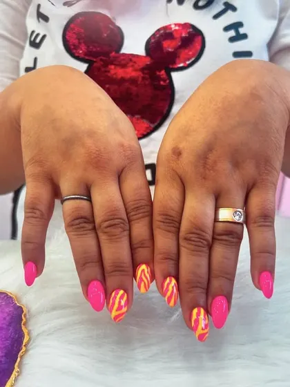 Perfect for a vacation, these nails feature a vibrant pink base with fiery orange and yellow flame-like art. This bold and energetic design is all about having fun in the sun.