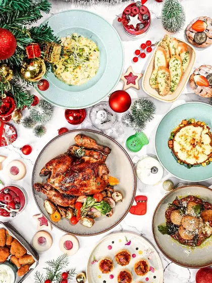 A festive Christmas brunch flatlay on a white marble surface. The top-down view captures the entire celebratory spread in a clean and organized composition.