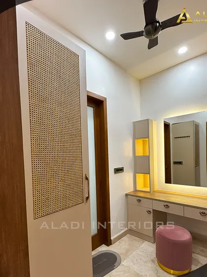 A stylish dressing nook featuring a vanity with a backlit mirror and a wardrobe with a cane-work panel door, blending modern and natural textures.