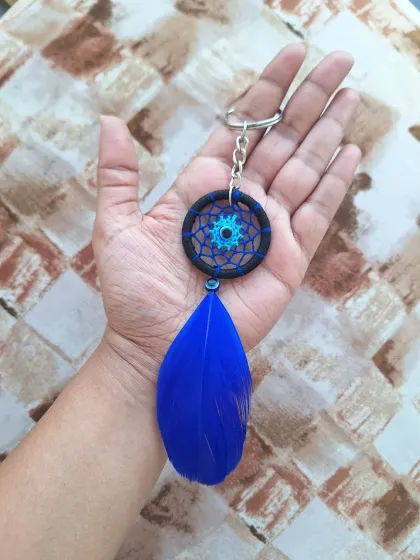 A classic blue and black dreamcatcher keychain. The deep blue feather adds a touch of simple elegance to this handmade accessory.