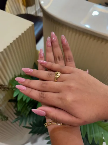 The almond shape and soft pink glitter combine for a look that is both elegant and feminine.