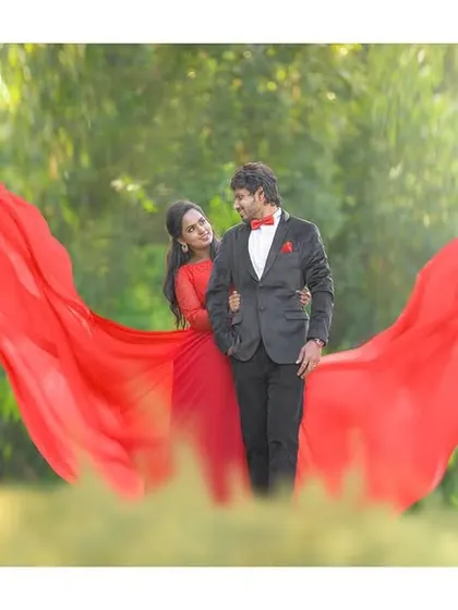 Creating the illusion of wings with a flowing red fabric. This is another example of how we use creative props to add a touch of magic to your pre-wedding photos.