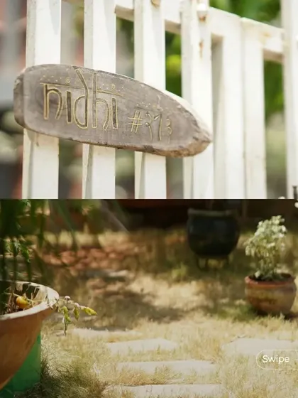 The rustic, hand-carved nameplate for "Nidhi" (#313), the Manjunath Residence, adds a personal and artisanal touch to the entrance.