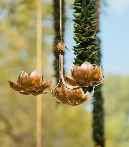 A hanging brass ornament in the shape of lotus flowers, adding a touch of metallic elegance to the organic decor.