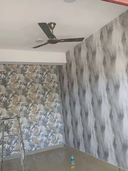 A room with two different wallpapers: a tropical leaf pattern and an abstract wave pattern. This shows how you can mix and match designs for a unique look.