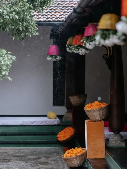 Rain falls on the Haldi decor, but the bright colors of the hanging baskets and marigold-filled pots continue to shine, proving that a good plan accounts for everything.