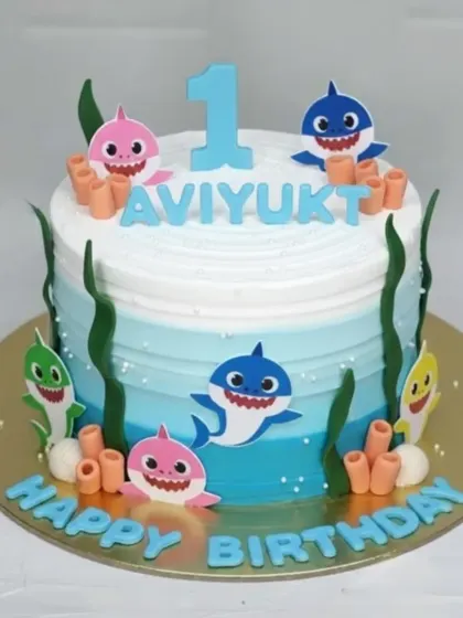 Doo doo doo doo doo doo! This Baby Shark first birthday cake is an underwater adventure. The rich eggless chocolate truffle base is covered in light whipped cream with an ombre blue effect.