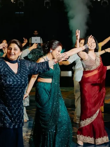 A group of ladies enjoying their performance together. The synchronized arm movements and happy faces show the unity and joy of a family dance.