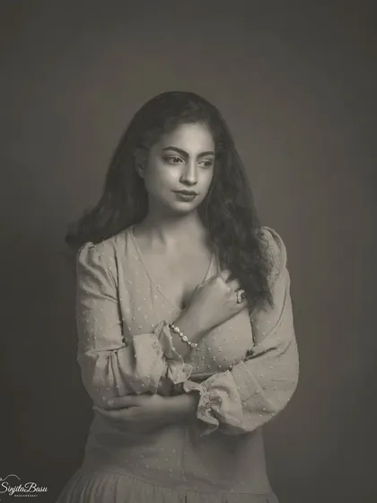 This image showcases the subtle beauty of a matte monochrome finish. The soft light and thoughtful pose create a quiet, elegant portrait. The black and white tones are deep and rich, giving the photograph the feel of a classic silver gelatin print.