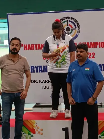 A shooter receives her medal on the winner's podium during the award ceremony I officiated.