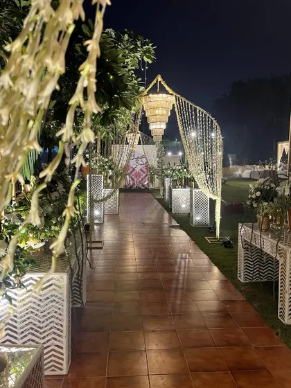 The well-lit walkway, adorned with cascading lights and lush greenery, makes for a perfect parting memory of a night to remember.