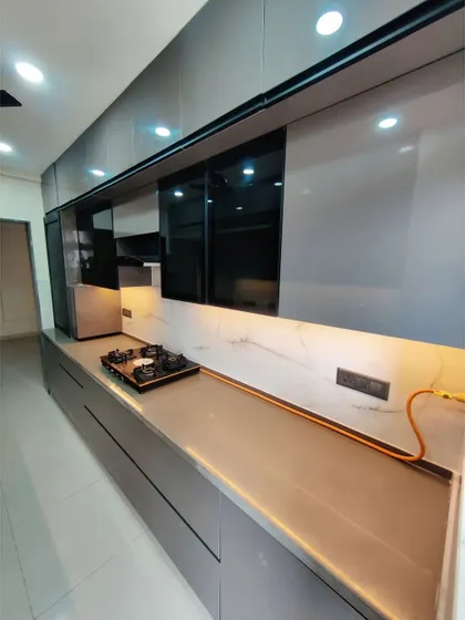 Another view of a modern parallel kitchen, showcasing the integrated hob and sleek, handleless drawers. This design is perfect for optimizing space in long, narrow kitchen areas.
