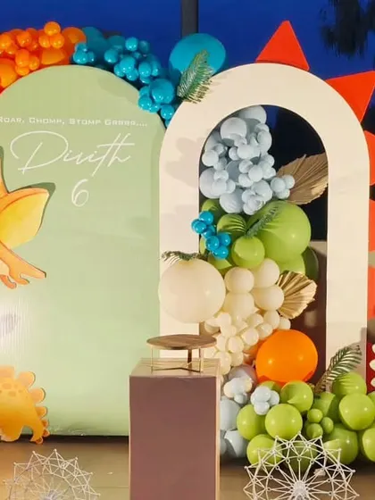 A modern take on a dinosaur theme, using arch-shaped backdrops and a stylish balloon arrangement.
