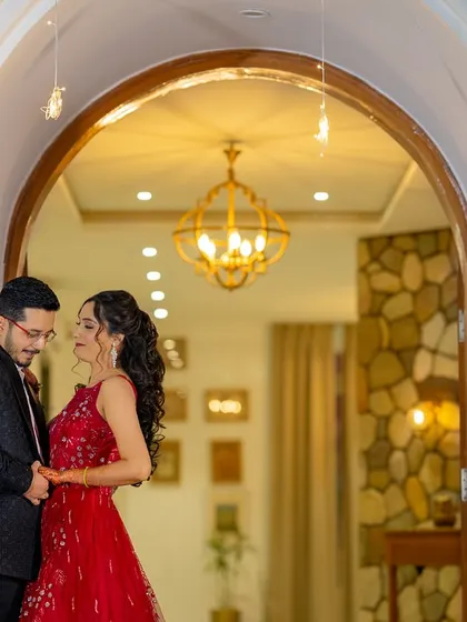 Framed in a beautifully lit archway, this shot feels like the beginning of a fairytale. The warm indoor lighting contrasts with the night outside, creating a cozy and romantic pre-wedding photo.