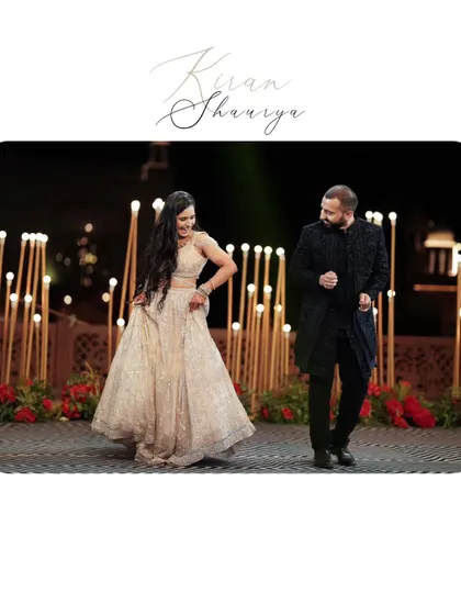 A candid shot of the couple dancing on stage, their smiles telling a story of pure happiness. The simple, elegant frame keeps the focus on their joy.