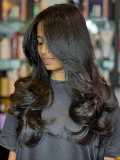 The final result of a precision layered cut. The soft curls at the end highlight the different lengths, creating a voluminous and dynamic style that looks effortlessly elegant.