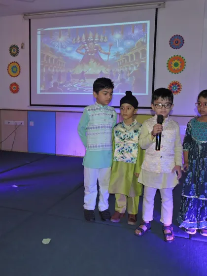 Four students stand together on stage, ready to share stories and songs about the festival of Dussehra.