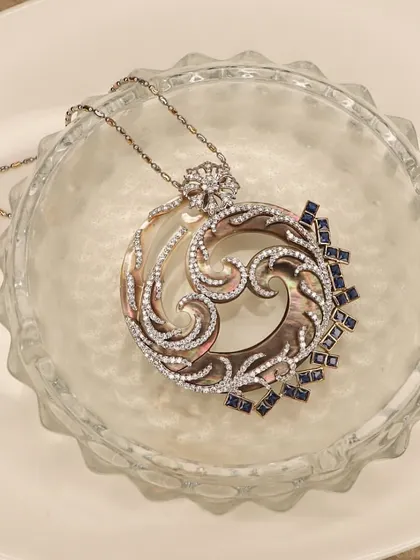A still shot of the movie-inspired pendant. The craftsmanship combines mother-of-pearl, diamonds, and sapphires to create a piece that is truly a work of art.