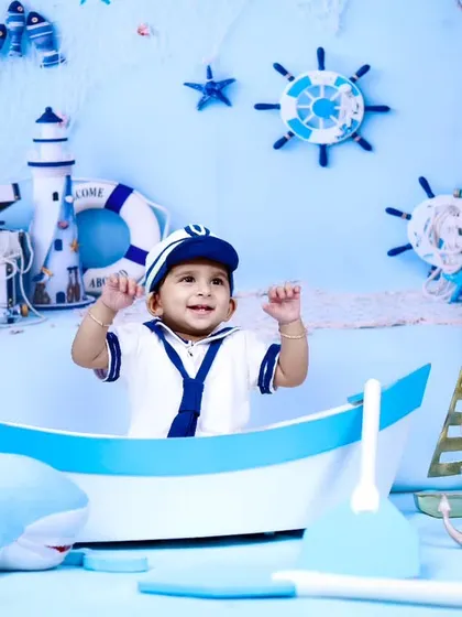 A wide shot of the sailor-themed setup, showing the baby's joyful expression.