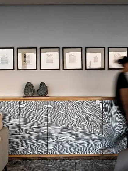A custom-designed credenza with a graphic black and white pattern serves as a focal point in this lounge on the director's floor of the Stainless Steel Office. The space is curated with unique art and furniture pieces.