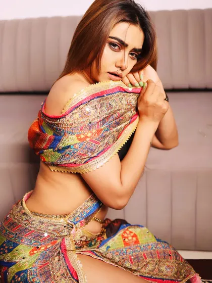 A sensual and artistic portrait in a colorful, modern-style saree. The pose is intimate and expressive, highlighting the unique drape of the fabric.