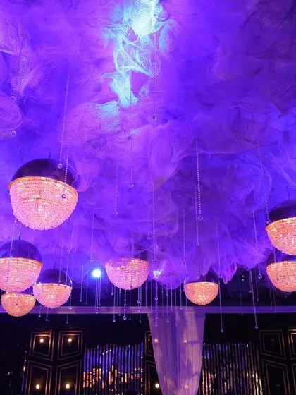 A different perspective of the purple-lit ceiling with spherical chandeliers, showing how the lighting interacts with the architecture of the room. This demonstrates our skill in using light to define and enhance a space.