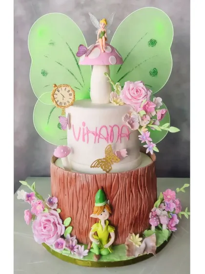 A clean shot of the two-tier Tinkerbell cake, showcasing the handcrafted fondant figures and delicate floral details.
