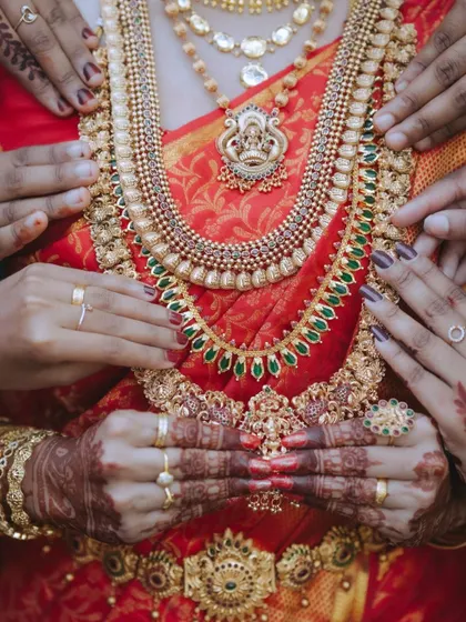 A detailed shot focusing on the layers of traditional temple jewellery worn by a South Indian bride, showcasing the cultural richness and artistry.