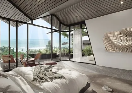 This bedroom in our Dona Paula project offers breathtaking sea views through floor-to-ceiling glass. The room's interior is kept minimal to reflect the dynamic, shifting form of the roof and to keep the focus on the incredible landscape outside.