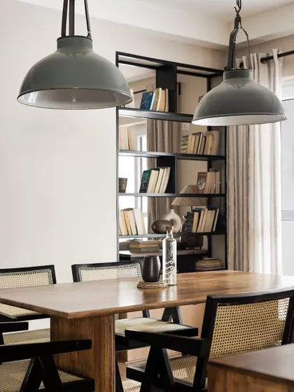 The dining area in 'Ikigai Living' is positioned next to a custom bookshelf, reflecting the client's love for reading. The space is perfect for meals and conversations surrounded by books.