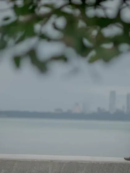 A candid shot capturing a quiet moment at Marine Drive, with the iconic Mumbai skyline in the background. This tells a story of love in the city.