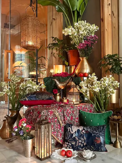A sneak peek of a future wedding decor mood board, featuring rich textiles, brass lanterns, and printed cushions.