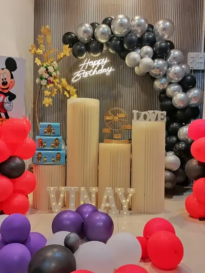I love creating fun themes for kids' birthdays. This setup features Mickey Mouse and Tom & Jerry cutouts, with light-up letters spelling the birthday boy's name, Vinay.