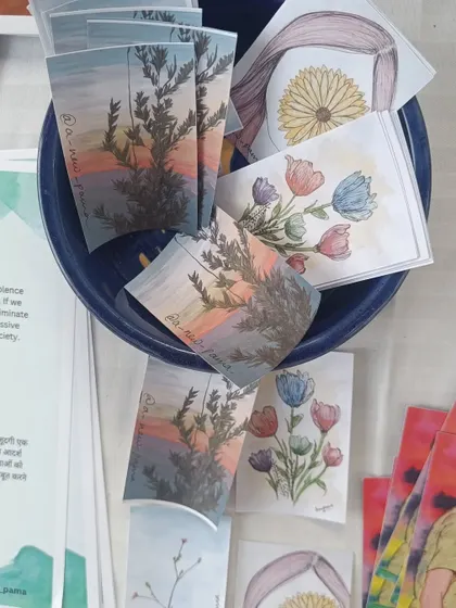 A close-up of a bowl filled with small art prints and bookmarks at my stall. These little pieces of art are like seeds of creativity, ready to be taken home and planted in new spaces.