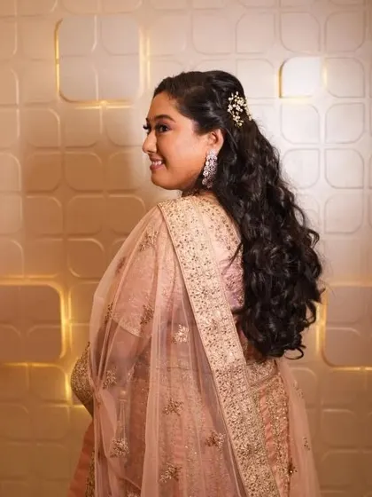 A side profile showing off her beautiful wavy hairstyle and the delicate hair accessory. This is a perfect example of a simple yet elegant reception hairstyle.