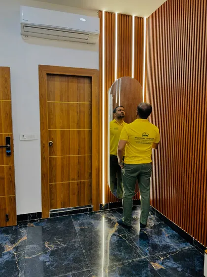 This dressing unit for a minimal space features a full-length mirror against a fluted wooden panel with integrated vertical lighting.