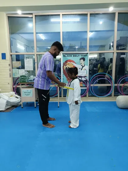 Tying a yellow belt for a young girl.