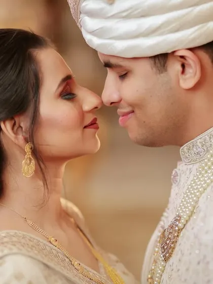 A classic nose-to-nose pose, capturing the sweet intimacy between the couple. The soft lighting and floral hairpiece add to the romantic feel.