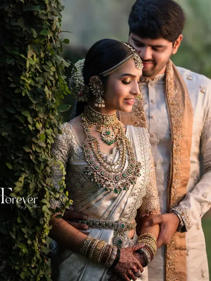 A romantic couple portrait. The bride's soft, glowing makeup and layered jewellery create a look of pure elegance next to her groom.