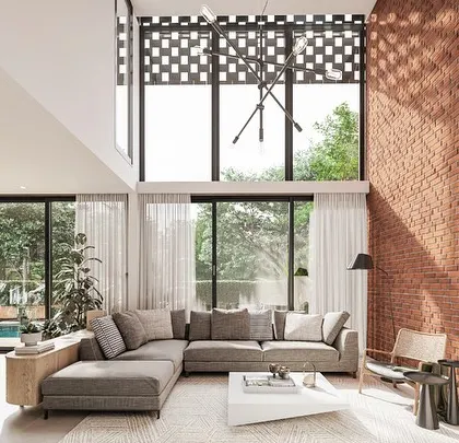 This living room from the Kolgaon Masterplan showcases our approach to material honesty. A double-height brick wall serves as the central feature, complemented by large glazing that floods the space with natural light and connects the home to the surrounding landscape.