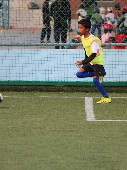 A player chases down a loose ball near the sideline, showing the hustle and effort we encourage in every game.