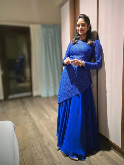 A client celebrating her birthday in a custom royal blue gown with an embroidered overlay.